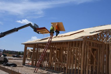 Yeni inşaat çerçeveleme işçiler tarafından istihdam edilmektedir inşaat şirketinden bir ekibi tarafından monte ediliyor. Bu evler Amerika Birleşik Devletleri'nin güneybatı parçası olan Arizona inşa ediliyor.