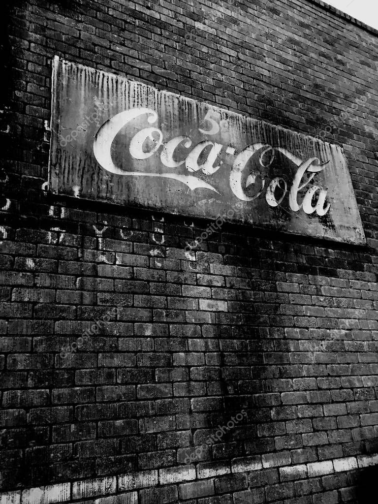Vintage Coke Cola sign hanging on a wall outside a restaurant in downtown Gilbert Arizona which is located in the Southwest part of the United States. This sign shows Coke Cola selling for five cents.