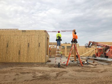 Yeni inşaat çerçeveleme işçiler tarafından istihdam edilmektedir inşaat şirketinden bir ekibi tarafından monte ediliyor. Bu evler Amerika Birleşik Devletleri'nin güneybatı parçası olan Arizona inşa ediliyor.