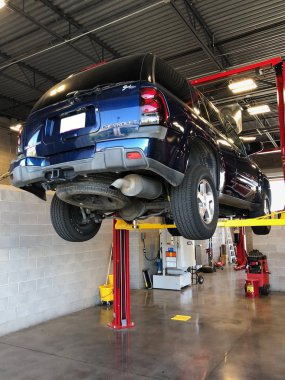 Bir araba araçlarda salonu onarım için kaldırma platformda onarın. Araba garajında, oto tamircisi arka planda özel Tamir ekipmanları ile hizmet.