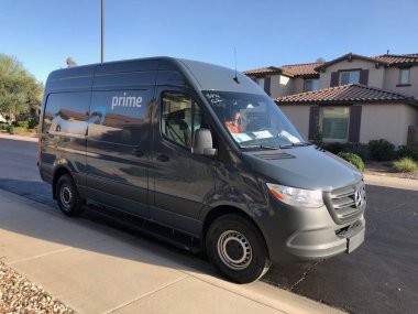Amazon Prime Delivery being made in a residential area of Gilbert, Arizona. Amazon Prime members in over 8,000 cities and towns can get either Free Same-Day Delivery or Free One-Day Shipping. clipart