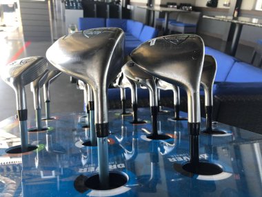 Golf kulüpleri müşteri için bir sürüş aralığında kutusunda oturan onlar topa vurmak için kullanmak için gidiyoruz hangi golf kulübü seçmek için.