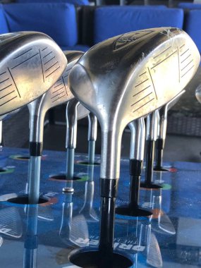Golf kulüpleri müşteri için bir sürüş aralığında kutusunda oturan onlar topa vurmak için kullanmak için gidiyoruz hangi golf kulübü seçmek için.