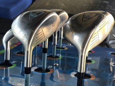 Golf kulüpleri müşteri için bir sürüş aralığında kutusunda oturan onlar topa vurmak için kullanmak için gidiyoruz hangi golf kulübü seçmek için.