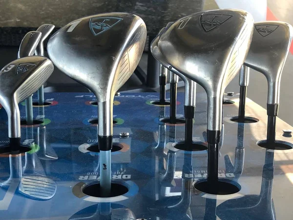 Golf kulüpleri müşteri için bir sürüş aralığında kutusunda oturan onlar topa vurmak için kullanmak için gidiyoruz hangi golf kulübü seçmek için.