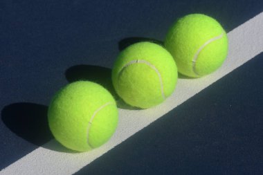 Tenis kortundaki tenis topları farklı tasarımlarda yaratıcı ışıklandırma ile soyut bir biçimde