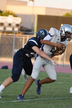 Arizona 'daki iki yerel okul arasında oynanan lise futbol maçı. Burada oyun oynanırken görüntüler oyun eyleminden.
