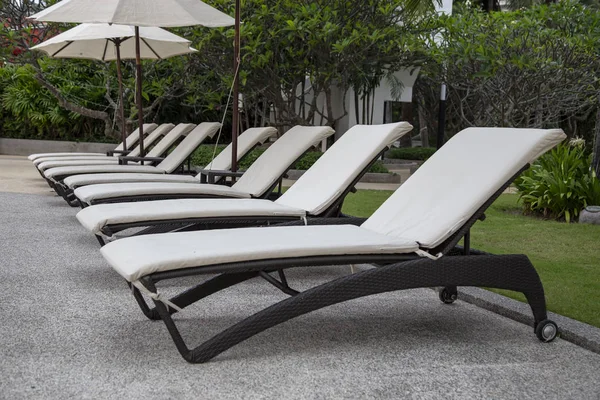 Chaises de plage et parasol à côté de la piscine — Photo