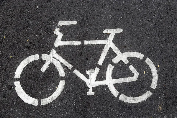Sign bicycle on black asphalt road — Stock Photo, Image