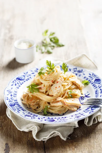 Chicken pasta with sweet chili sauce, fresh parsley and grated cheese