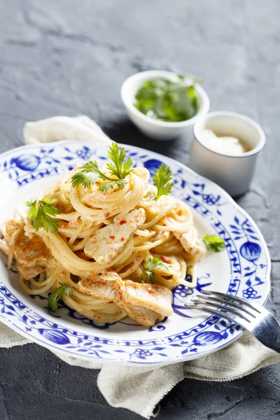 Chicken pasta with sweet chili sauce, fresh parsley and grated cheese