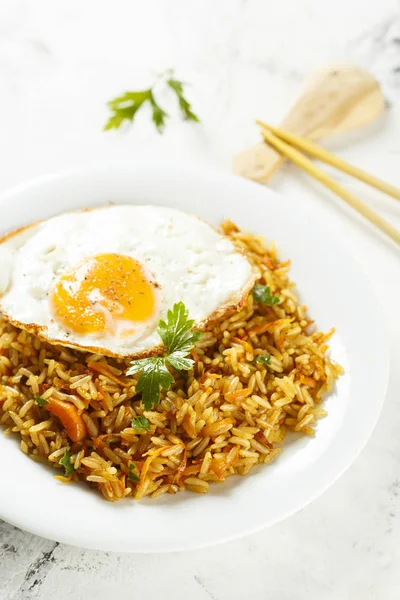 Traditional Asian fried rice with vegetables and fried egg
