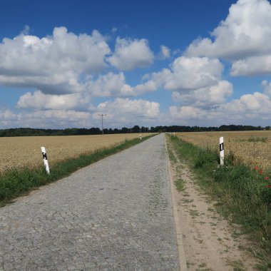 scenic view of empty road and clouds in blue sky