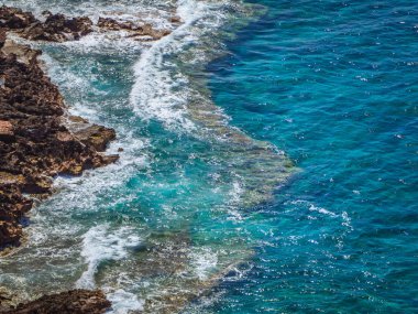 Kayalık sahilleri kenarında açık mavi deniz