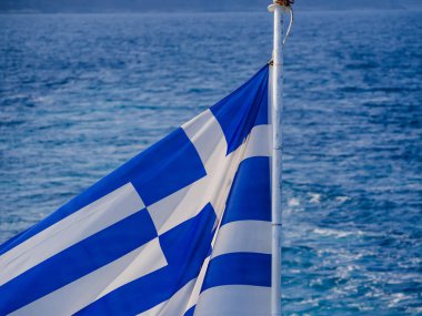 Rüzgarda Yunanistan Bayrağı ve arka planda güzel deniz