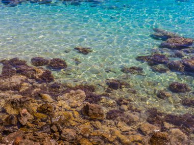 Kayalık kıyıya yakın güzel mavi sığ deniz suyu