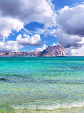 İnanılmaz tropikal plaj, berrak mavi sakin deniz, arka planda ada ve güzel gökyüzü