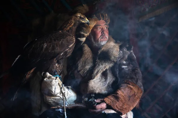 Old kazakh eagle hunter with his golden eagle.