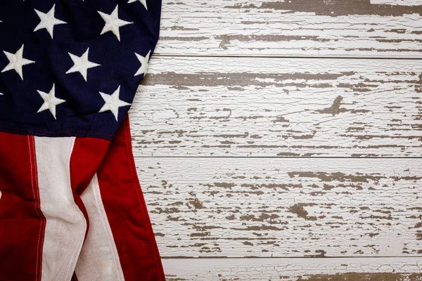 Una bandera americana arrugada sobre un fondo de tablón blanco con espacio de copia para vacaciones, etc. . — Foto de Stock