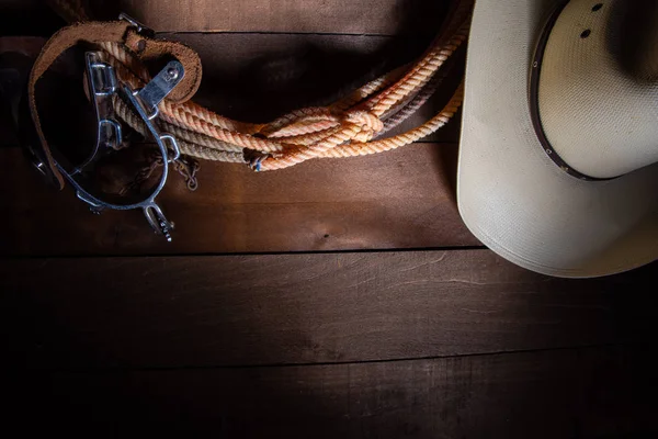 Cowboy americano Itens que incluem um esporão de laço e um chapéu de palha tradicional em um fundo de prancha de madeira — Fotografia de Stock