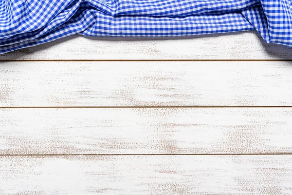 A checked gingham picnic tablecloth on old wooden table top view — Stock Photo, Image