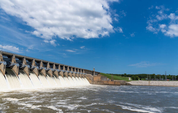 Вода вытекает из открытых ворот гидроэлектростанции
