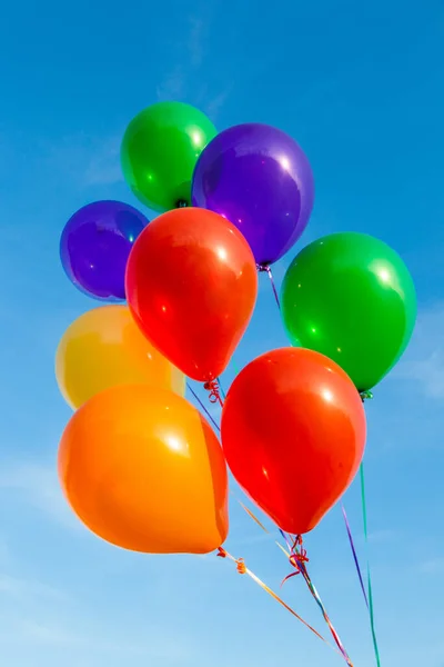 Färgglada ballonger på en vacker blå himmel — Stockfoto