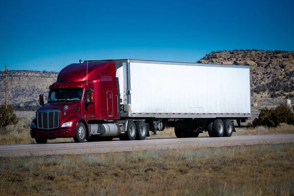 An Eighteen wheel big rig tractor trailer on highway. Trucking industry