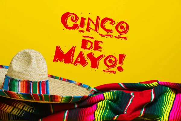 Mexikanska Serape filt och sombrero på gul bakgrund med Cinco de Mayo. — Stockfoto