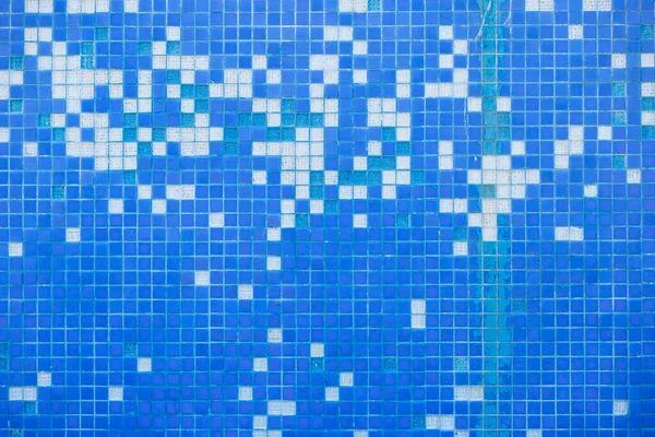Turquoise tiles on walls of pool fell off in places and need repair. Grunge texture. Restoration.
