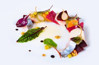 Salad or appetizer of salted fish with boiled vegetables - beets, carrots, potatoes, cucumbers, spices, herbs, sauce, capers, mustard on white background. Gourmet salad Herring under fur coat.