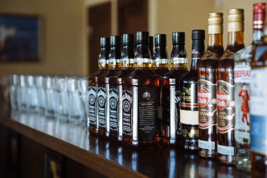 Bottles of alcoholic drinks stand on bar counter in restaurant bar. Party or bachelor party. Assortment of alcohol.