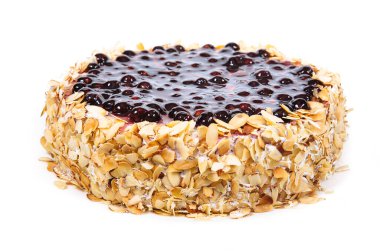 Sponge cake with berries and nuts is covered with fruit glaze and nut chips. View from above. Birthday or holiday. Confectionery.