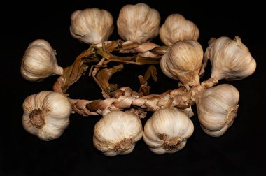 Siyah arka planda bir grup sarımsağın yatay fotoğrafı.