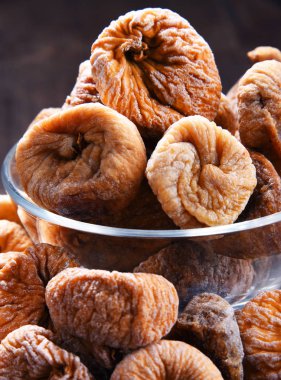 Ahşap masada bir kase kurutulmuş incir ile kompozisyon.