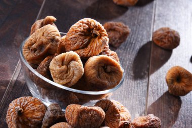 Ahşap masada bir kase kurutulmuş incir ile kompozisyon.