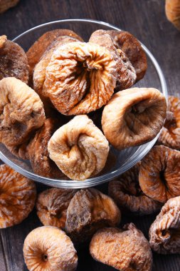 Ahşap masada bir kase kurutulmuş incir ile kompozisyon.