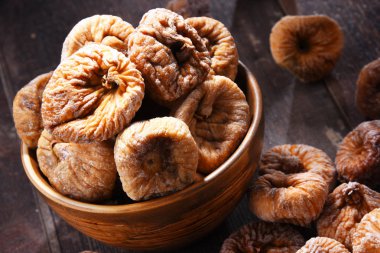 Ahşap masada bir kase kurutulmuş incir ile kompozisyon.