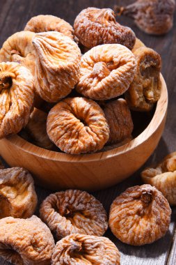 Ahşap masada bir kase kurutulmuş incir ile kompozisyon.