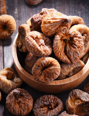 Ahşap masada bir kase kurutulmuş incir ile kompozisyon.