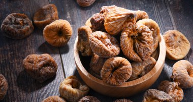 Ahşap masada bir kase kurutulmuş incir ile kompozisyon.