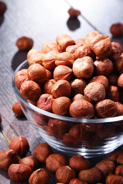 Bowl with hazelnuts on wooden table. Delicacies