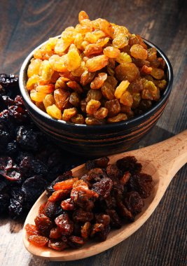 Tahta masada bir kase kuru üzümlü kompozisyon..