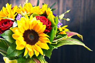 Ayçiçekleri ve güller de dahil olmak üzere bir buket çiçekle kompozisyon