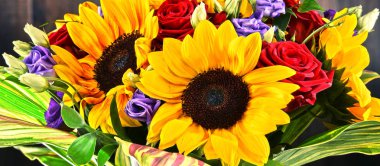 Ayçiçekleri ve güller de dahil olmak üzere bir buket çiçekle kompozisyon