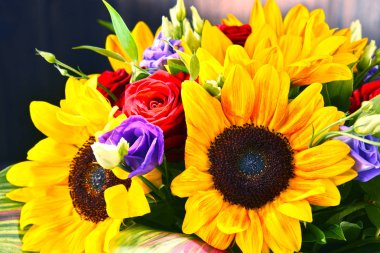 Ayçiçekleri ve güller de dahil olmak üzere bir buket çiçekle kompozisyon