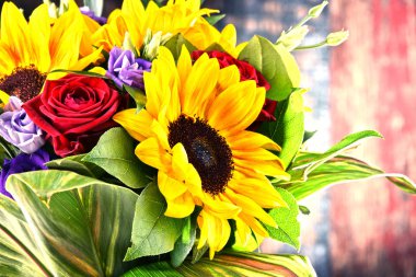 Ayçiçekleri ve güller de dahil olmak üzere bir buket çiçekle kompozisyon