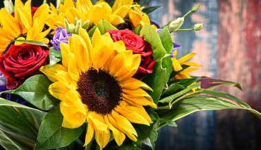 Ayçiçekleri ve güller de dahil olmak üzere bir buket çiçekle kompozisyon