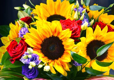 Ayçiçekleri ve güller de dahil olmak üzere bir buket çiçekle kompozisyon