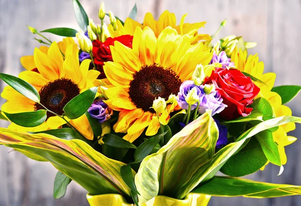 Composition with bouquet of flowers including sunflowers and roses